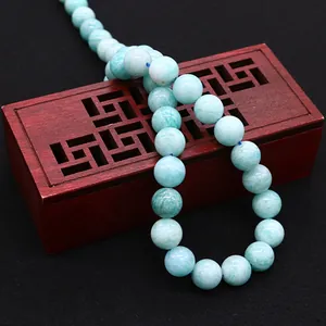 Polished natural amazonite round beads for DIY jewelry making on vintage wood box