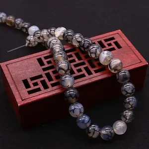 Natural dragon vein agate round beads on a vintage wooden box for DIY jewelry making