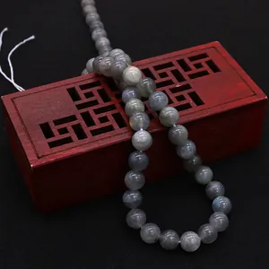 Natural labradorite round beads showing blue flash effect on a decorative wooden box
