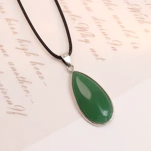 Vista macro del ciondolo a goccia in avventurina verde con castone argento e cordino nero