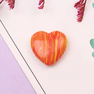 Detalle macro del colgante de piedra sintética en forma de corazón con patrón de llama