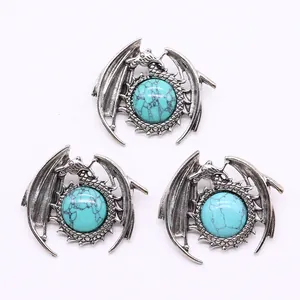 Detailed view of silver dragon pendant set with turquoise stone on white background