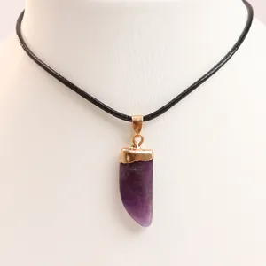 Detail of purple natural stone amethyst pendant with gold plated cap on black necklace