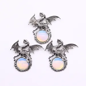 Three vintage silver dragon pendants clutching opalite gemstones on white background