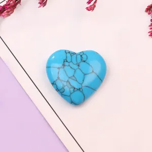 Primer plano de piedra turquesa azul en forma de corazón con patrones de telaraña negra en pastel