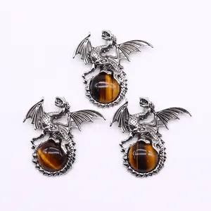 Detailed view of silver Viking dragon pendants clutching spherical tiger eye stones