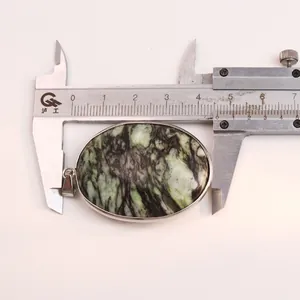 Detailed view of an oval Brazilian turquoise pendant with silver trim, measuring 4.5cm