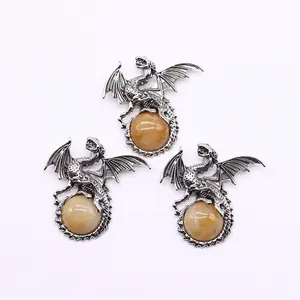 Macro detail of antique silver dragon pendants holding yellow tiger eye stones