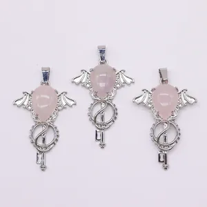 Detail view of pink crystal angel wing pendants with silver metal key-shaped base