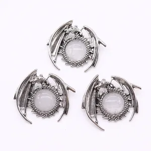 Detailed macro view of three vintage silver dragon pendants with white moonstone inlays