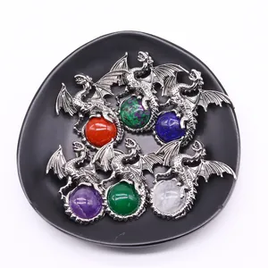 Silver dragon pendants with colorful gemstone spheres in a black display tray