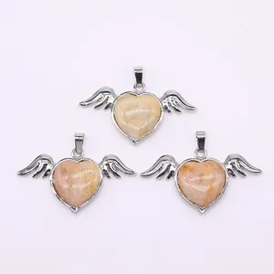 Macro shot of three angel wing heart pendants with natural stone inlay and silver finish
