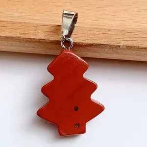 Macro shot of red natural stone Christmas tree pendant with polished silver clasp detail