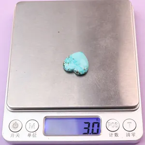 Foto macro de piedra turquesa en corazón de 3g en báscula mostrando peso exacto y textura