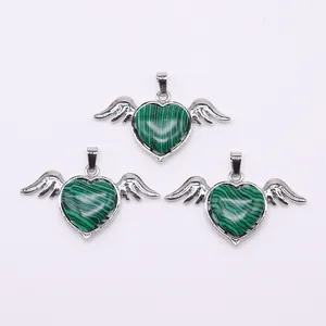 Detail of three heart-shaped angel wing pendants with green malachite in silver frames