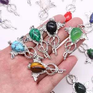 Gothic bat wing key pendants with teardrop natural stones held in hand for scale