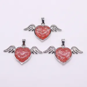 Detailed macro view of heart-shaped angel wing pendants with natural pink stone texture