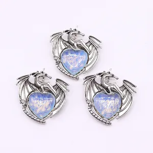 Macro detail of antique silver dragon heart pendants with vibrant blue moonstone center