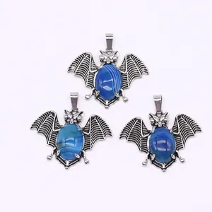 Detail van vleermuisvormige hangers met blauwe ovale stenen in zilveren afwerking