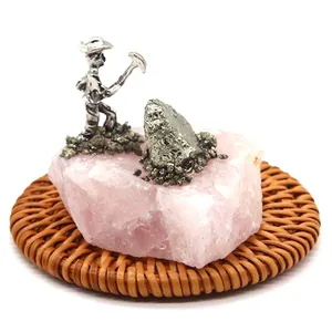 Figura creativa de minero sobre racimo de cristal rosa natural para decoración mesa