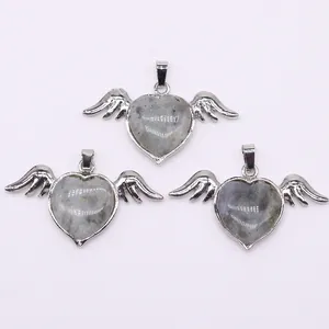 Macro shot of three silver angel wing pendants with heart-shaped natural gemstones