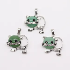 Detalle de tres colgantes con forma de gato de piedra verde y marcos de metal plateado