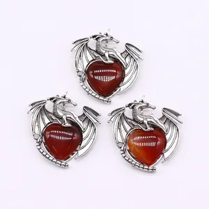 Detailed view of dragon-wrapped heart-shaped red agate pendants with vintage silver finish