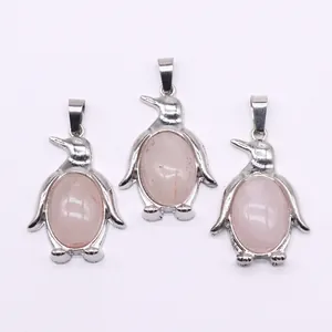 Detailweergave van drie pinguïnhangers met ovale roze kwarts in een zilveren setting