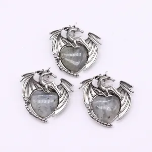 Detailed view of dragon-shaped pendants with heart-shaped natural grey stone inlays