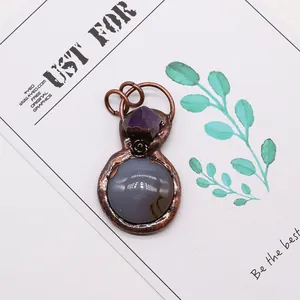 Macro shot of bronze gourd pendant with amethyst, agate stone and carved rose motif