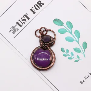 Detail showing vintage bronze pendant with purple agate stones on a white artistic card