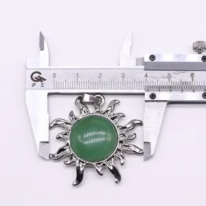 Ausmessen eines silbernen Sonnenanhängers mit grünem Stein, zeigt 42mm Durchmesser