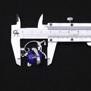 Detalle de colgante de gato con piedra natural medido con calibre mostrando 2,8cm