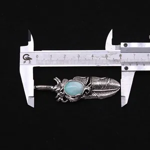 Federanhänger-Messung zeigt ca. 5,6 cm Länge mit blauem Steininlay auf schwarzem Grund
