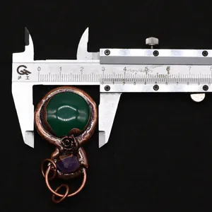 Macro shot measuring vintage pendant width with a caliper showing 30mm size detail