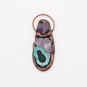 Detailed shot of long agate slice pendant with amethyst raw stones and bronze setting