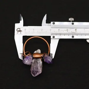 Detailed view of raw purple amethyst pendant with measurements using a caliper tool