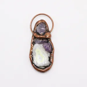Detailed macro view of electroplated copper pendant with purple amethysts and agate slice