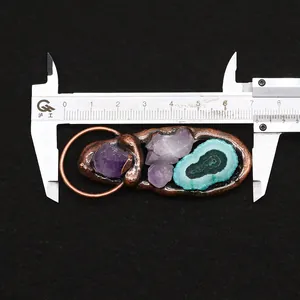 Macro view of long agate slice and purple amethyst pendant with copper metal wrapping