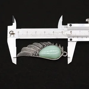 Detail of wing-shaped stone pendant measuring 5.8cm length on a caliper display