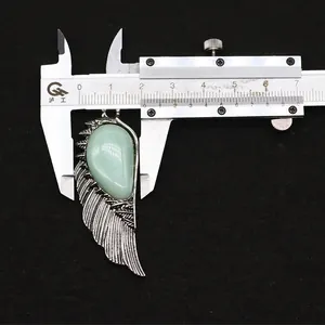 Macro view showing natural stone wing pendant measured at 1.8cm with a digital caliper