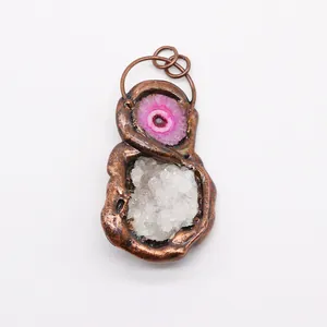 Detail of handmade bronze electroformed pendant with natural agate slice and white druzy crystal
