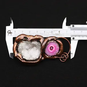 Macro shot measuring an irregular natural crystal and agate pendant with bronze plating