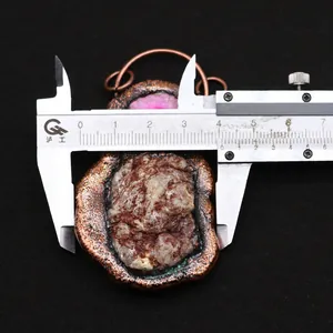 Detailed dimension shot showing a 4.2cm width bronze natural stone pendant with pink crystal