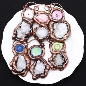 Natural crystal cluster pendants with antique bronze frames in assorted colors on white plate