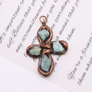 Macro shot of bronze cross pendant with natural turquoise stones on vintage background