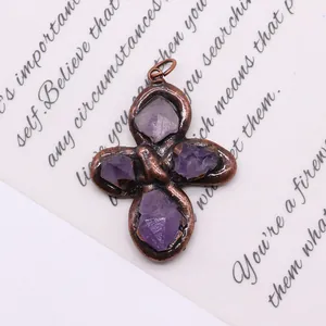 Detailed macro view of vintage bronze flower pendant with purple raw crystal stones