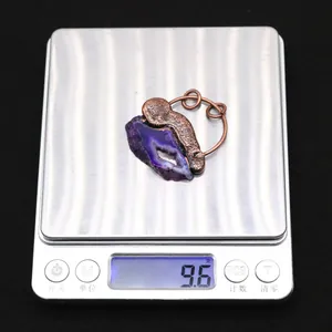 Detailansicht eines lila Achat-Anhängers mit einem Gewicht von 9,6 g auf einer Digitalwaage