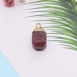 Détail macro du pendentif en pierre naturelle violette de forme cube avec fermoir en métal doré