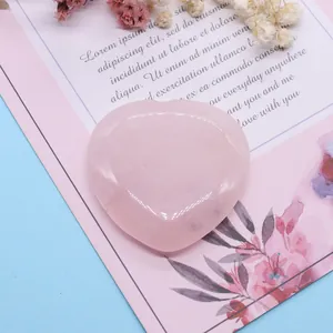 Pierre de cristal de quartz rose polie en forme de cœur sur une carte cadeau décorative
